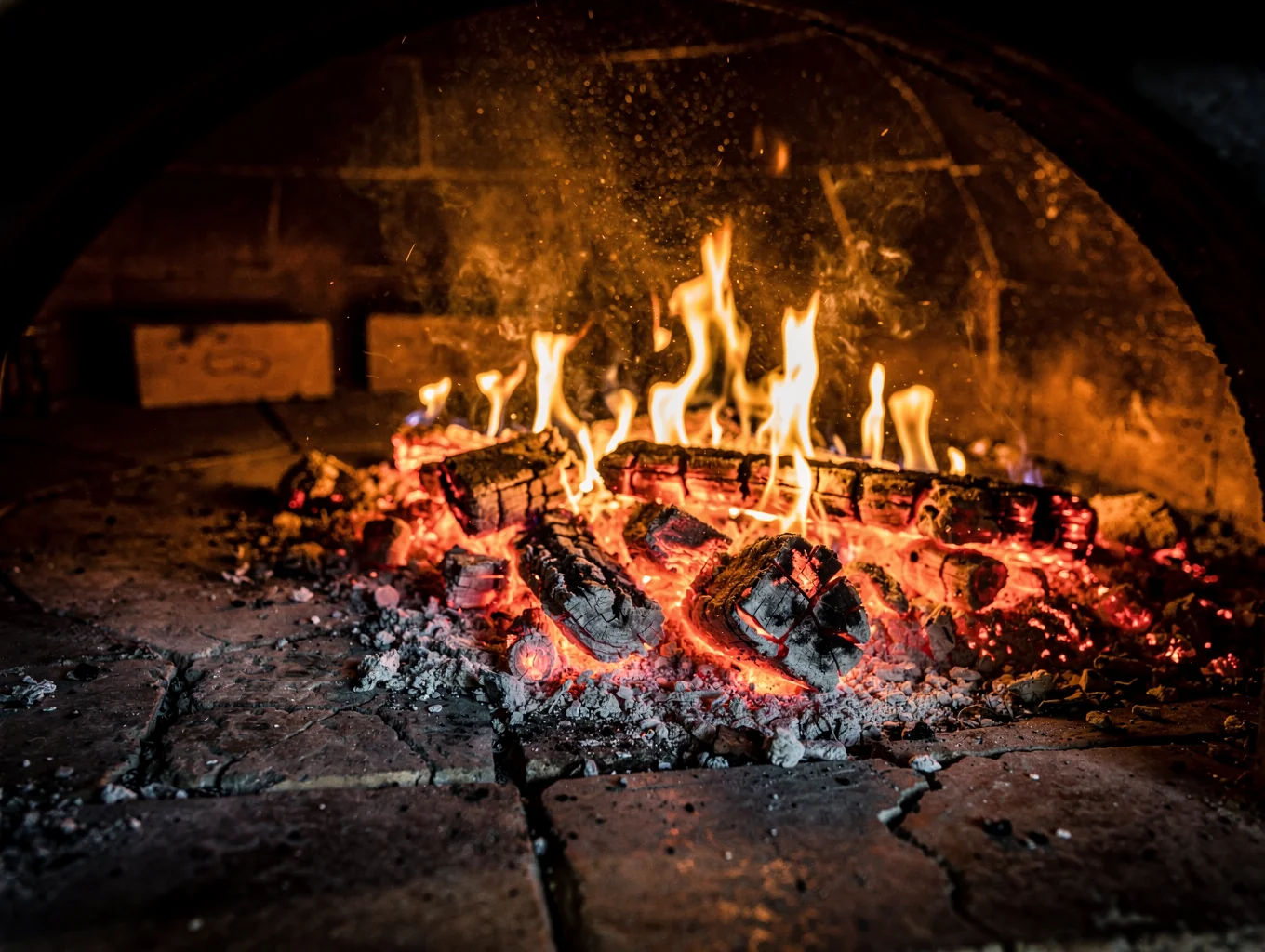Glowing embers inside a traditional stone oven